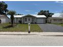 Inviting single-story home featuring a well-kept lawn, a charming palm tree, and a convenient paved driveway at 4833 Dogwood St, New Port Richey, FL 34653
