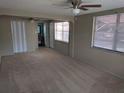 Spacious main bedroom featuring carpeted floors, ceiling fan, and en-suite bathroom at 4833 Dogwood St, New Port Richey, FL 34653