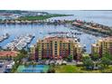 Attractive condo building with harbor view, featuring manicured landscaping and tennis courts at 606 Riviera Dunes Way # 306, Palmetto, FL 34221