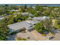 This aerial showcases a home with a modern metal roof and a screened-in pool, nestled in a serene, tree-filled neighborhood at 7202 18Th Nw Ave, Bradenton, FL 34209