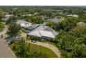 Aerial view of a well-maintained home featuring lush greenery, a metal roof, and a spacious driveway at 7202 18Th Nw Ave, Bradenton, FL 34209