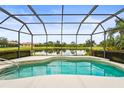Relaxing screened-in pool overlooks a peaceful lake with beautiful landscaping around the pool area at 8118 Stirling Falls Cir, Sarasota, FL 34243