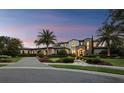 Stunning home with a circular driveway, arched entrances, manicured lawn, and vibrant flower beds, creating a picturesque estate at 8316 Portlight Ct, Lakewood Ranch, FL 34202