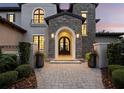 Close-up of an elegant front entrance with an arched stone doorway and custom iron door at 8316 Portlight Ct, Lakewood Ranch, FL 34202
