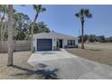 Attractive single-story house boasting a gray garage door and mature palm trees enhancing the curb appeal at 904 Winter Garden Dr, Sarasota, FL 34243
