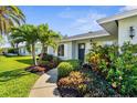 Landscaped front yard with lush tropical plants and a welcoming walkway to the front door at 913 64Th W St, Bradenton, FL 34209
