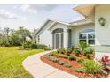 Inviting entrance with a decorative landscape bed and a well-maintained lawn leading to the front door at 10001 289Th E St, Myakka City, FL 34251