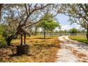 Scenic shot of a gravel driveway, well, and fenced-in property at 10001 289Th E St, Myakka City, FL 34251
