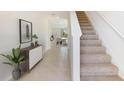 Bright entryway featuring tile flooring, carpeted stairs, and an open view into the dining and living areas at 12036 Lansing Gln, Parrish, FL 34219