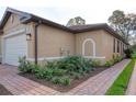 Side view of a single-Gathering home with landscaped yard and brick driveway at 12091 Firewheel Pl, Venice, FL 34293