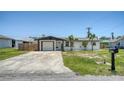 Inviting single-story home with a well-manicured lawn and driveway leading to an attached garage at 1227 Porpoise Rd, Venice, FL 34293