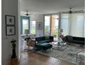 Bright living room featuring contemporary furniture, neutral tile floors, and sliding glass doors to the balcony at 130 Riviera Dunes Way # 304, Palmetto, FL 34221
