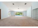 Spacious living room with neutral carpet, fan and access to lanai & pool at 13511 4Th Plz E, Bradenton, FL 34212