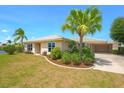Charming single-story home featuring lush landscaping, well-manicured lawn, and a convenient attached garage at 1450 Aqui Esta Dr, Punta Gorda, FL 33950