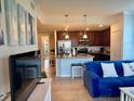 Open-plan living room with kitchen beyond, blue couch, and neutral tile floor at 16904 Vardon Ter # 201, Bradenton, FL 34211