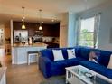 Living room with tile flooring, kitchen with granite countertops, and a comfortable blue couch at 16904 Vardon Ter # 201, Bradenton, FL 34211