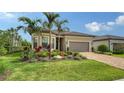 Landscaped front yard of the home features a paver driveway and tropical foliage at 17905 Waterville Pl, Bradenton, FL 34202