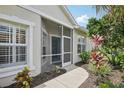 Inviting screened entrance featuring a concrete walkway and vibrant, well-maintained landscaping at 1831 San Silvestro Dr, Venice, FL 34285