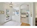 Open foyer featuring wood floors, light walls, and arched doorway with a view to the dining room at 1831 San Silvestro Dr, Venice, FL 34285