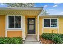 Welcoming front entrance with a black door, complemented by lush landscaping and clear house numbers at 1930 Peppermill Dr, Clearwater, FL 33763