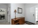 Welcoming foyer featuring a console table, decorative lamp, and access to the laundry room at 2160 Brandon Park Cir, Brandon, FL 33510
