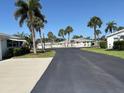 This shows the community street lined with palm trees and well maintained landscaping at 2218 Orange Blossom Ln # 0, Bradenton, FL 34207
