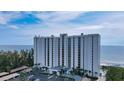 Modern condo building with floor-to-ceiling windows and well-maintained landscaping at 2425 Gulf Of Mexico Dr # 6A, Longboat Key, FL 34228
