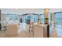 Open-concept living area with tile flooring, ocean view and comfortable white furnishings at 2425 Gulf Of Mexico Dr # 6A, Longboat Key, FL 34228