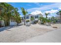 Inviting two-story beach house with palm trees and white gravel landscaping at 302 And 304 Canal Rd, Sarasota, FL 34242