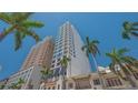 Exterior view of high rise condo building with balconies, surrounded by palm trees against a clear blue sky at 33 S Palm Ave # 1303, Sarasota, FL 34236