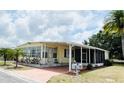 Inviting single-story home boasting a covered carport, mature landscaping, and a tidy exterior at 3318 Oakwood S Blvd, Sarasota, FL 34237