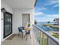Cozy balcony with seating area overlooking the waterfront and boat docks at 3320 Gulf Of Mexico Dr # 208C, Longboat Key, FL 34228