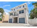 A modern two-story home with a light exterior, balcony, and a two-car garage at 340 Avenida De Mayo, Sarasota, FL 34242