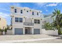 Bright two-story house with a small balcony and two-car garage, surrounded by a white fence at 340 Avenida De Mayo, Sarasota, FL 34242