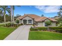 Beautiful single-story home with lush landscaping, a tile roof and a three-car garage at 385 165Th Ne Ct, Bradenton, FL 34212