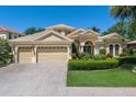 Beautiful home featuring a three car garage, well-manicured landscaping, and a welcoming front entrance at 4584 Tuscana Dr, Sarasota, FL 34241