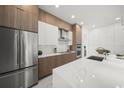 Kitchen with stainless steel refrigerator, modern cabinets, and a large center island with white countertop at 4726 Rivetta Ct, Sarasota, FL 34231