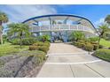 Entrance to a condo building, featuring manicured landscaping and a pathway at 475 Benjamin Franklin Dr # 211, Sarasota, FL 34236