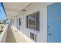 Exterior view of a condo with white siding, light blue door, and beach views at 475 Benjamin Franklin Dr # 211, Sarasota, FL 34236