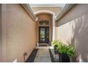 Inviting entryway with a glass front door, elegant sidelights, and decorative potted plants at 5091 Creekside Trl, Sarasota, FL 34243