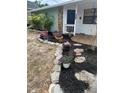 Charming front yard with stone walkway, lush mulch beds, and vibrant potted flowers enhancing curb appeal at 5094 Bunyan St, Sarasota, FL 34232