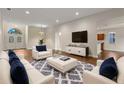 Bright, updated living room with hardwood floors, modern furniture, and large front windows and entry at 6248 Donnington Ct, Sarasota, FL 34238