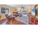 Cozy living room featuring hardwood floors, comfortable leather seating, and a sliding glass door to the backyard at 6422 Auburn Ave, Bradenton, FL 34207