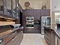 Modern kitchen with dark cabinetry, stainless steel appliances, and stone countertops at 7320 Melaleuca Way, Siesta Key, FL 34242