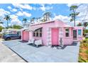 A pink house with a unique exterior featuring a garage, and charming curb appeal at 8 Desoto E St, Bradenton, FL 34208