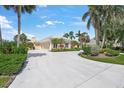 Exterior shot of a house showing a large, neutral colored three-car garage and extended driveway at 8 Dominica Dr, Englewood, FL 34223