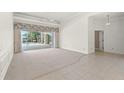 Spacious living room featuring tile and carpet flooring leading to screened-in pool and patio area at 8 Dominica Dr, Englewood, FL 34223