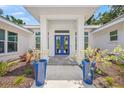 Covered front entrance with blue double doors flanked by matching blue potted plants at 924 Indian Beach Dr, Sarasota, FL 34234
