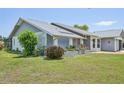 Well-kept house featuring neat landscaping, flower beds, and a walkway, complemented by a clean, gray and white exterior at 104 Hourglass Dr, Venice, FL 34293