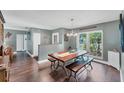Cozy dining room with a farmhouse table, wooden floors, and view of entryway and a large window at 1612 Shady Leaf Dr, Valrico, FL 33596